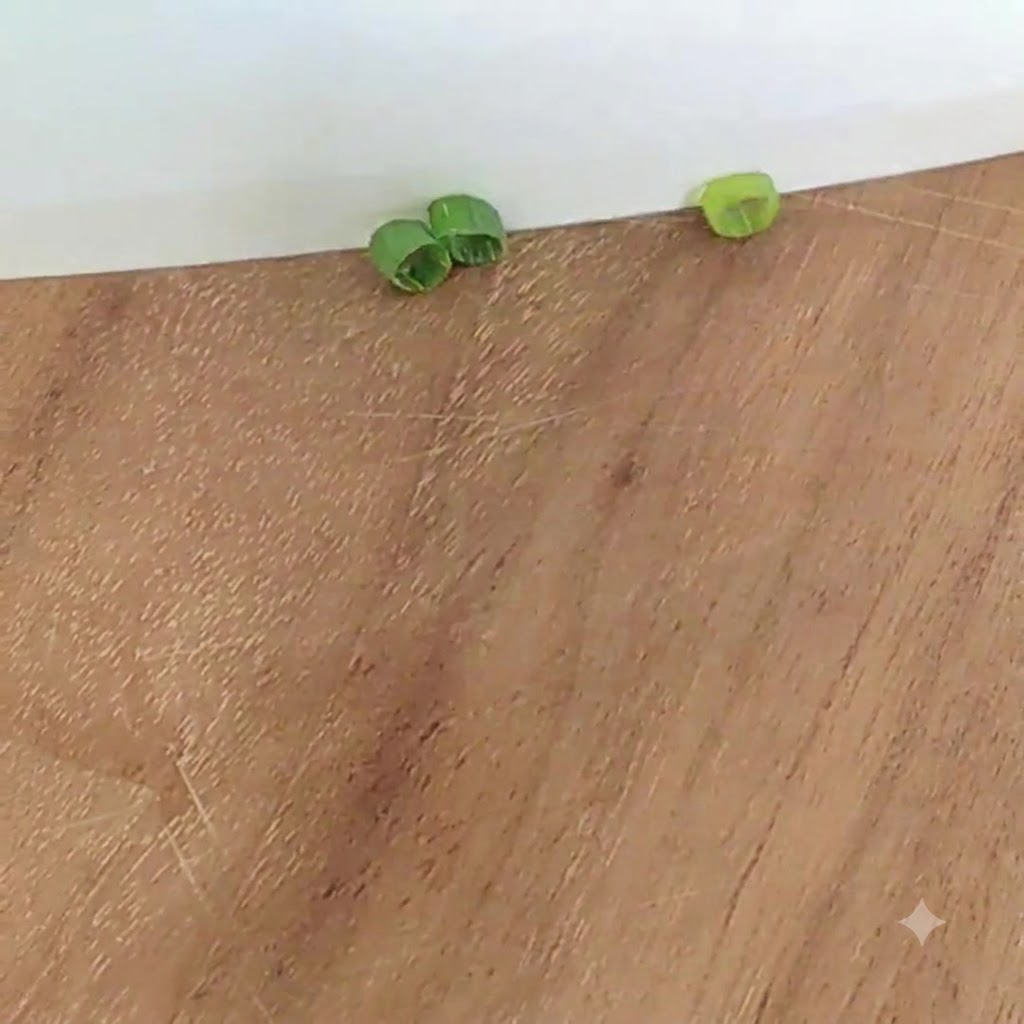 Green onion slices on a wooden cutting board.