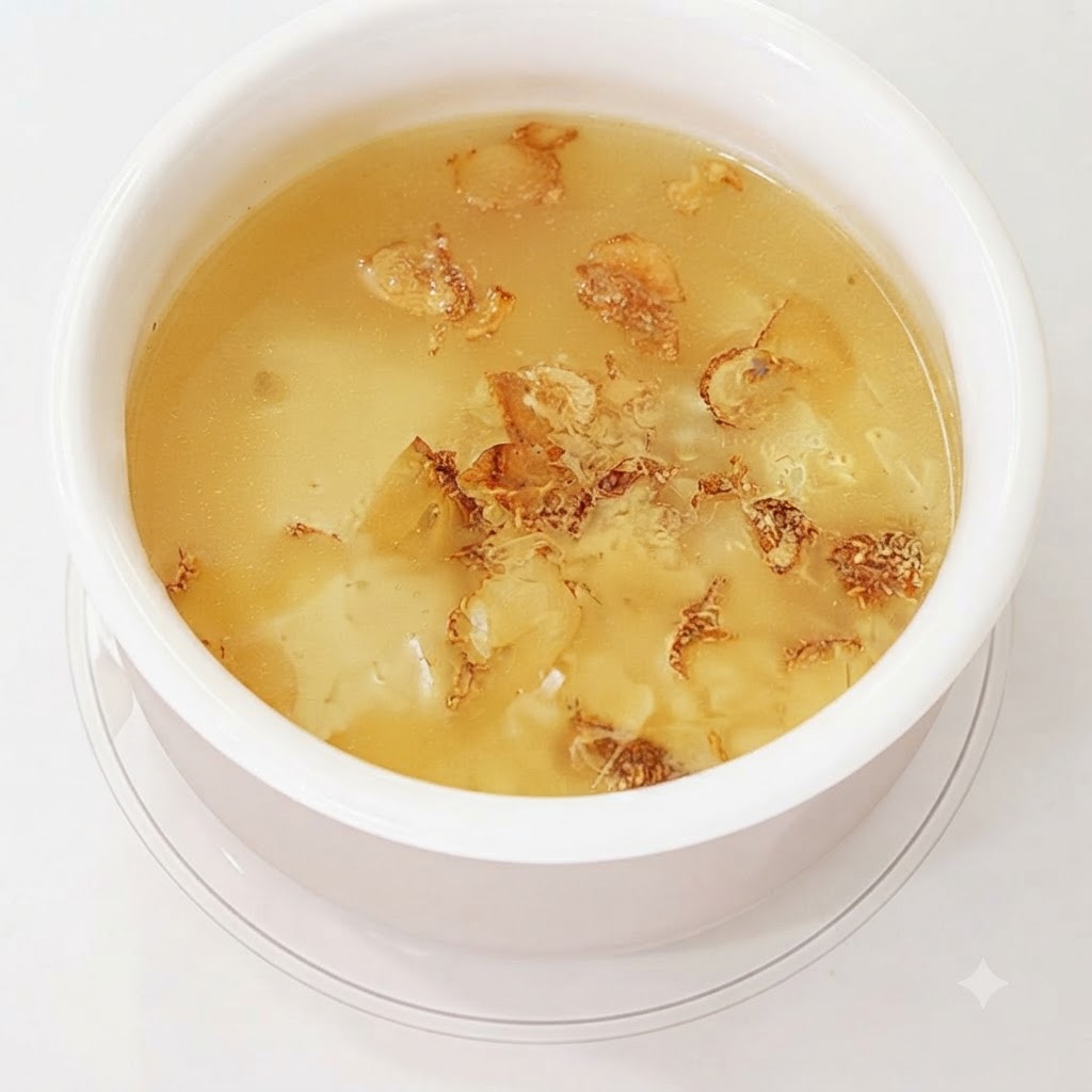 Garlic skins and cloves boiling in water to form a broth.