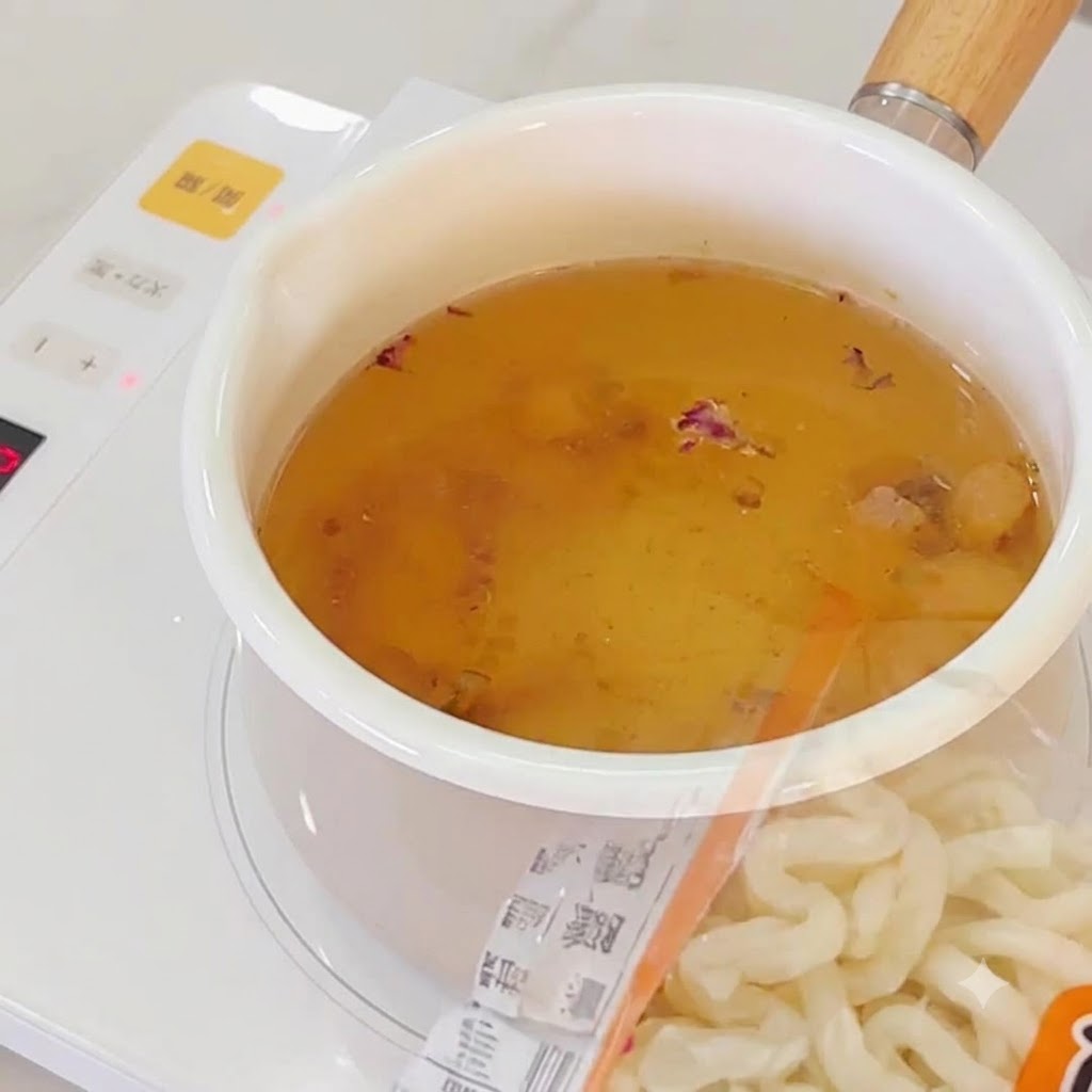 Ramen noodles being added to the boiling garlic broth.