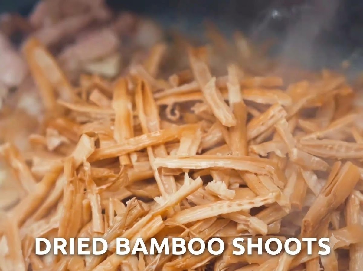 Dried bamboo shoots being stir-fried in a wok with meat.