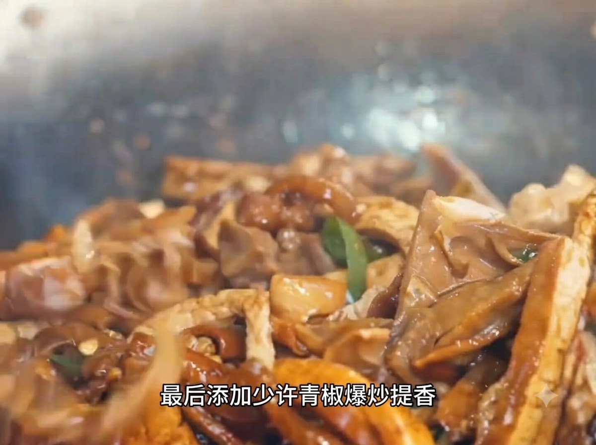 A close-up view of sliced green peppers being stirred into a bubbling, savory mix of pork and bamboo shoots inside a wok.