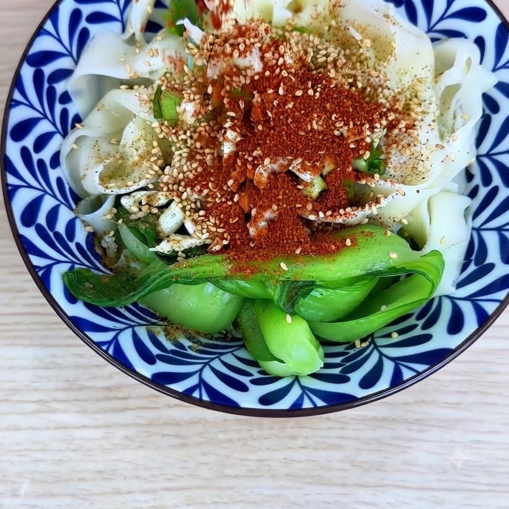 Fine chili powder and coarse chili powder sprinkled evenly on top of the noodles and seasonings in the bowl.