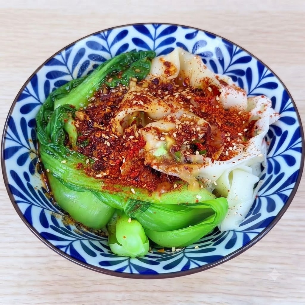 Hot oil being poured over the mound of chili powder and aromatics, causing them to sizzle inside the bowl.