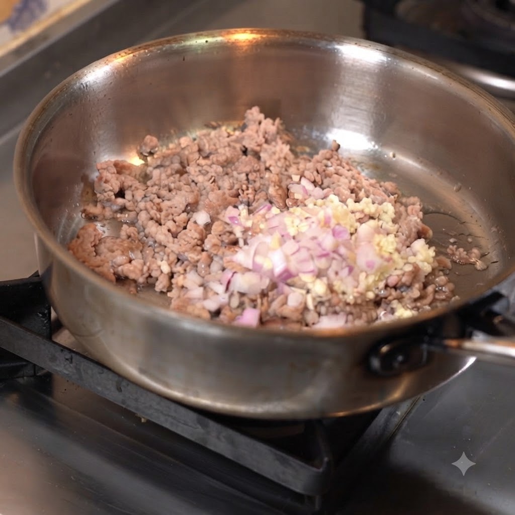Minced meat being stir-fried in a pan with chopped garlic and onions.