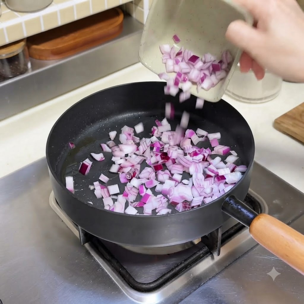 Diced red onions being poured from a small dish into a hot frying pan.