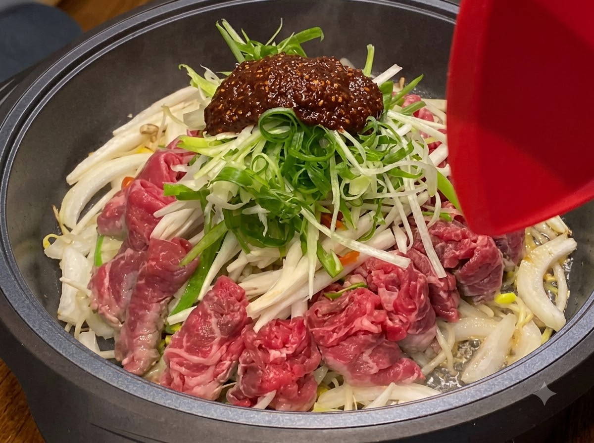 Ingredients being mixed and stir-fried together inside a heated cooking pan.