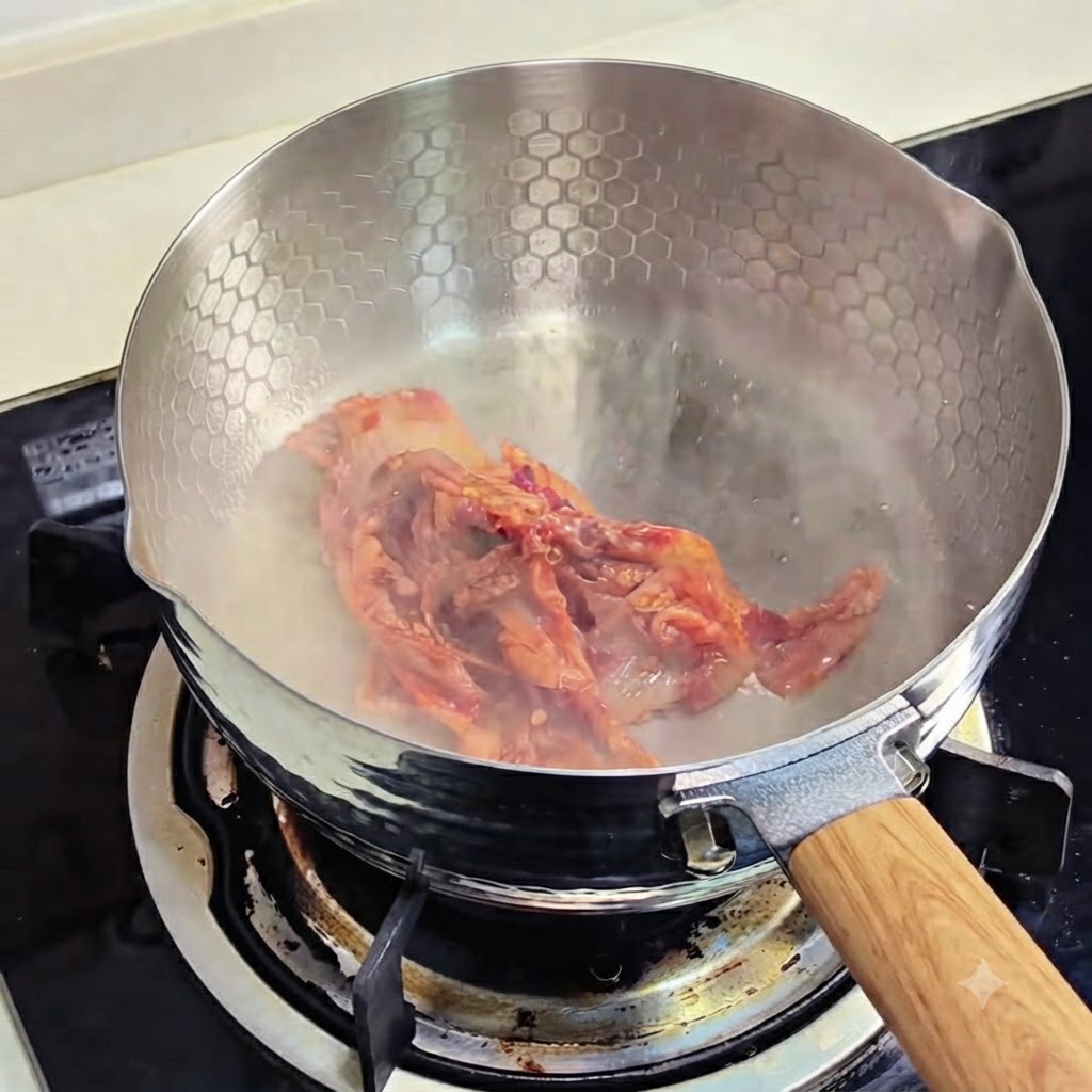 Kimchi pieces sizzling and frying in a cooking pan.