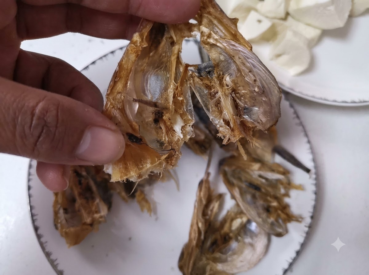 A close-up view of dried fish heads being opened and cleaned with a knife.