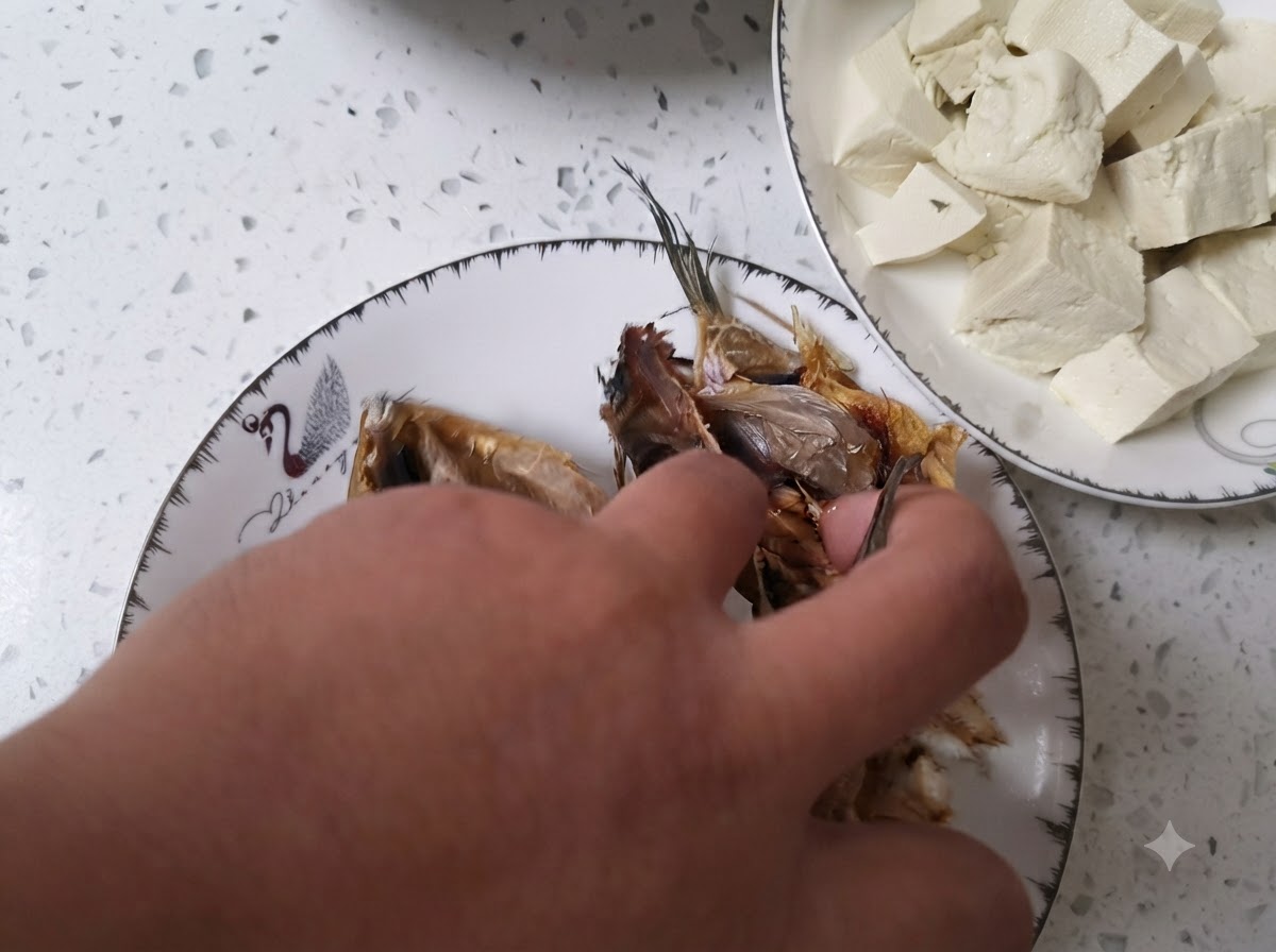 Cleaned dried fish heads being rinsed inside a bowl filled with clear water.