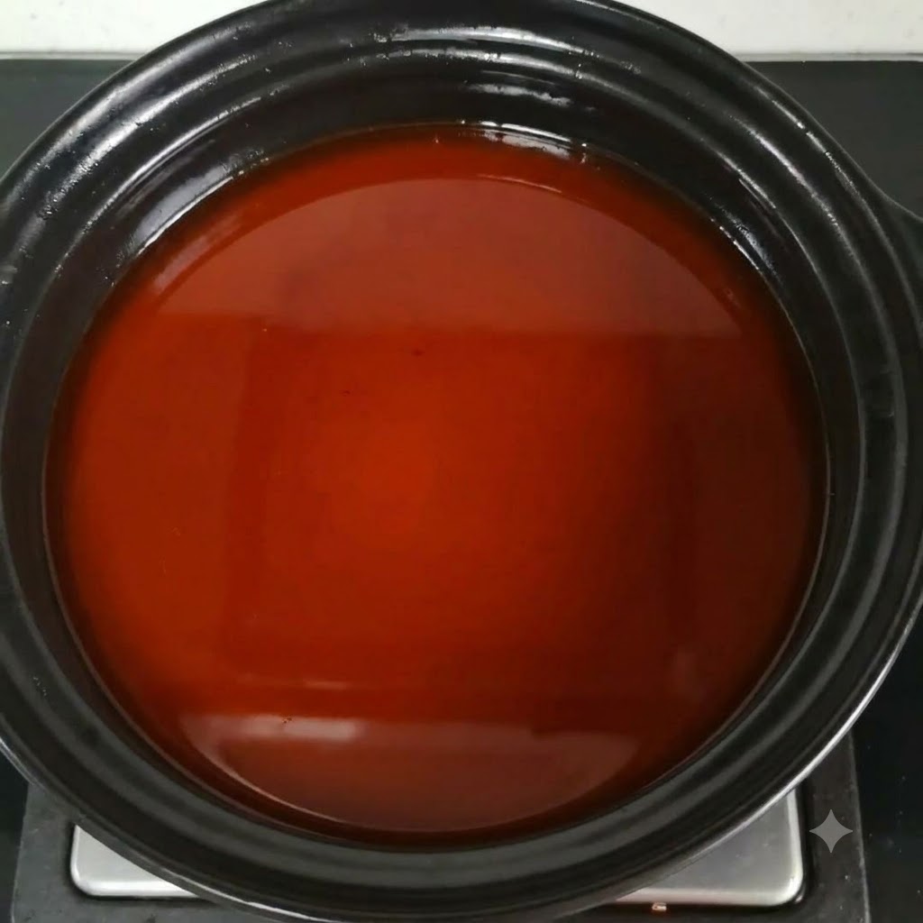 Fish sauce being mixed into the reddish-brown soup broth in the pot.