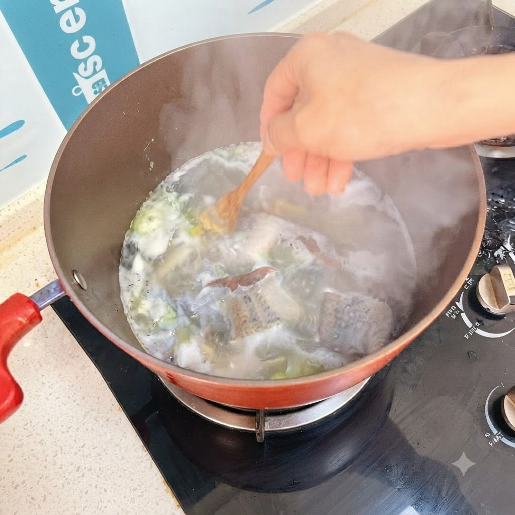 Tofu cubes being stirred into the bubbling soup using a wooden spoon.