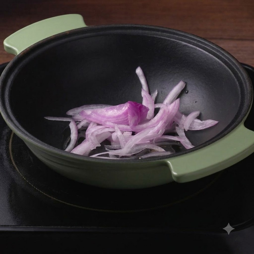 Shredded cabbage piled on top of sliced red onions inside a dark green pot.