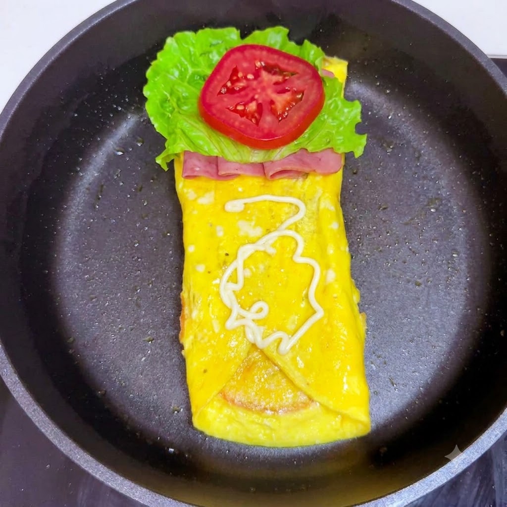 White salad dressing being drizzled in a spiral pattern over the tomato slice.