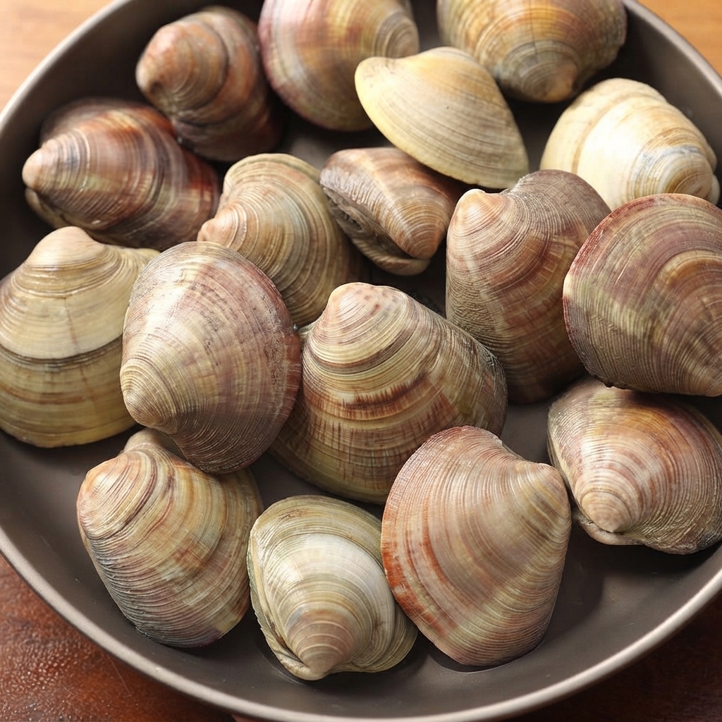 Fresh American hard clams displayed in a dark serving dish.