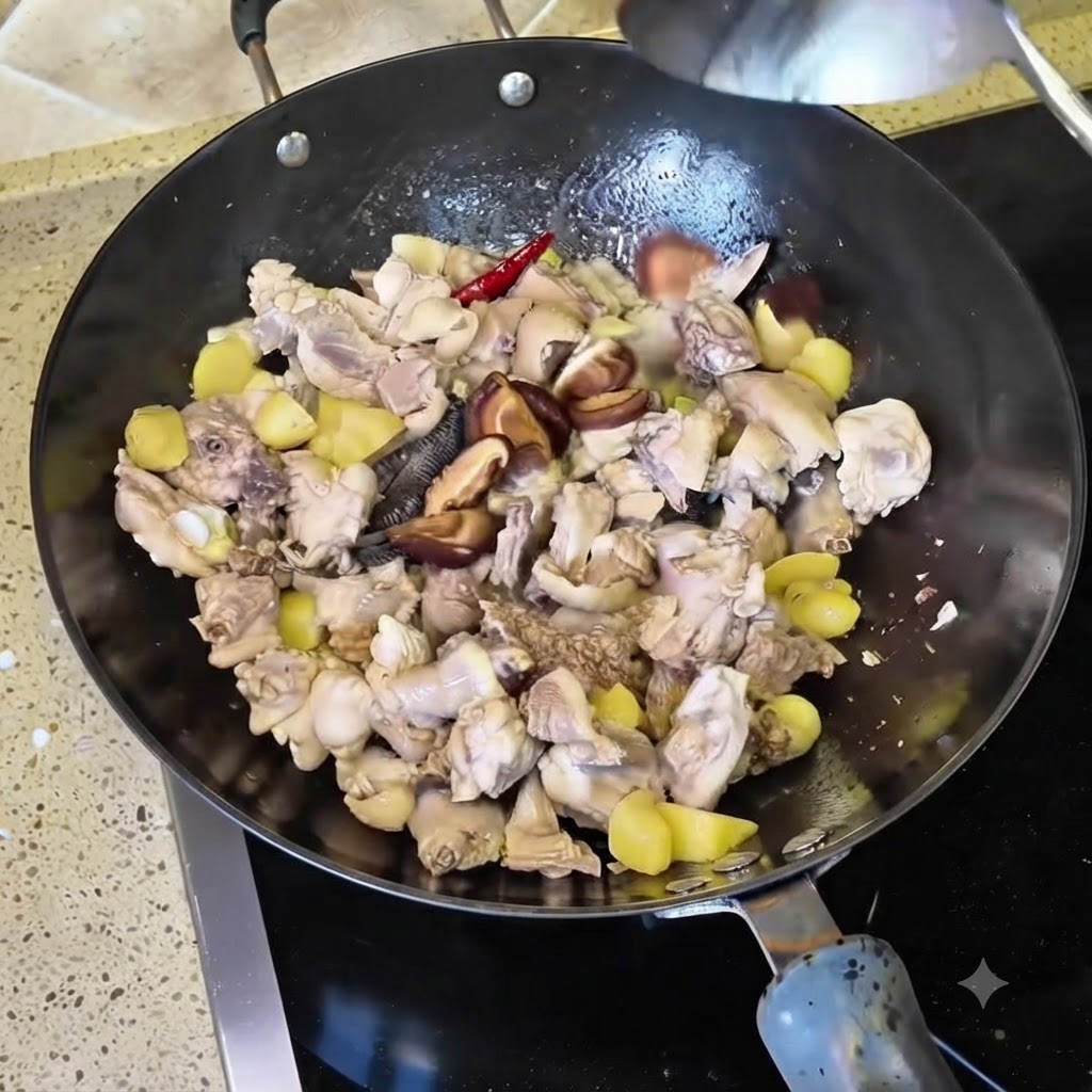 Soaked dried shiitake mushroom pieces mixed into the wok with chicken and aromatics.