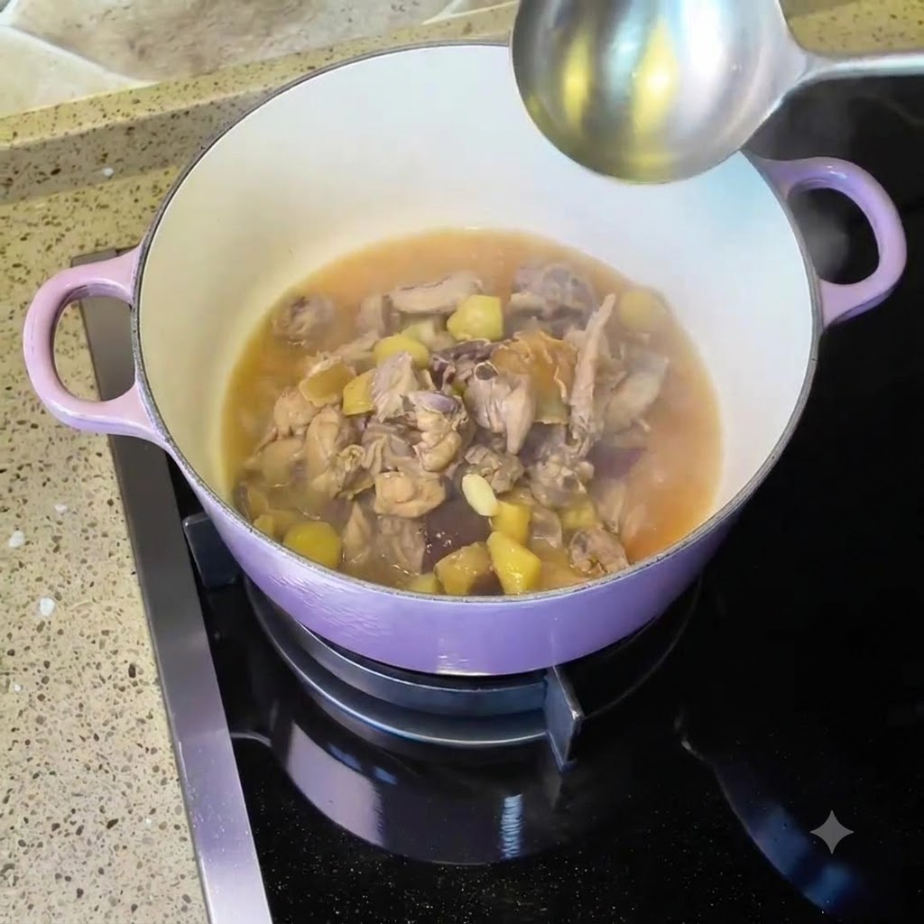 Chicken and soup simmering inside a purple Dutch oven on the stovetop with a ladle nearby.