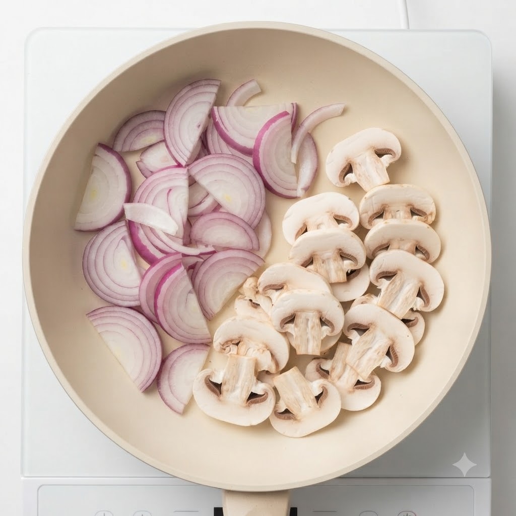 Sliced mushrooms mixed with red onions cooking together in a pan.