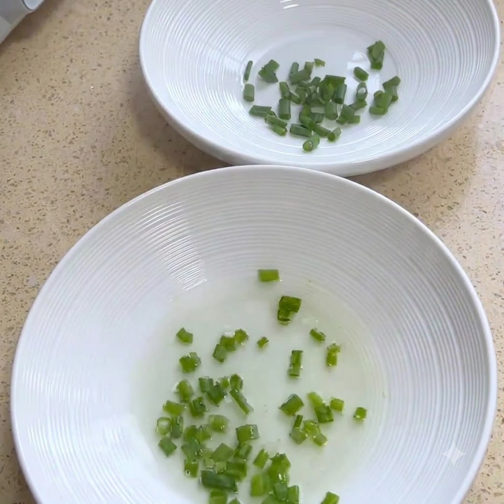 White serving bowls containing chopped green onions.