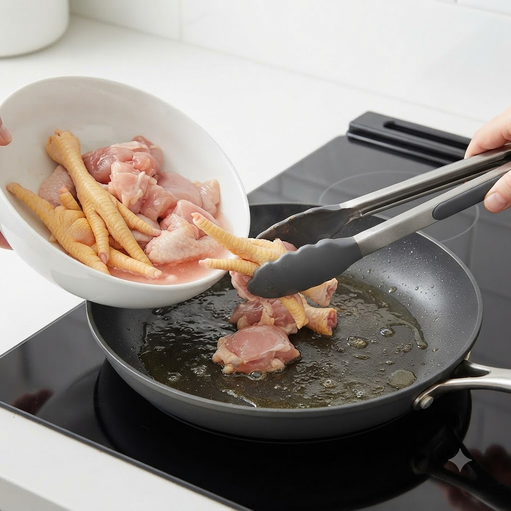 Raw chicken pieces being poured and placed with tongs into a pot of boiling water.