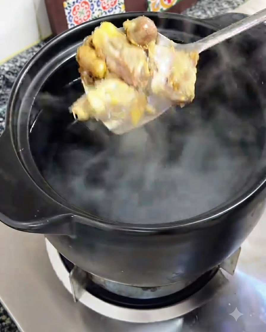 Browned chicken pieces being lifted on a spoon and transferred into a black clay pot of boiling water.