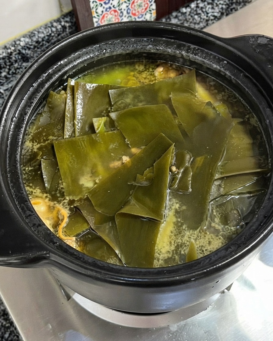 Chicken essence seasoning powder being added into the simmering chicken and kelp soup.