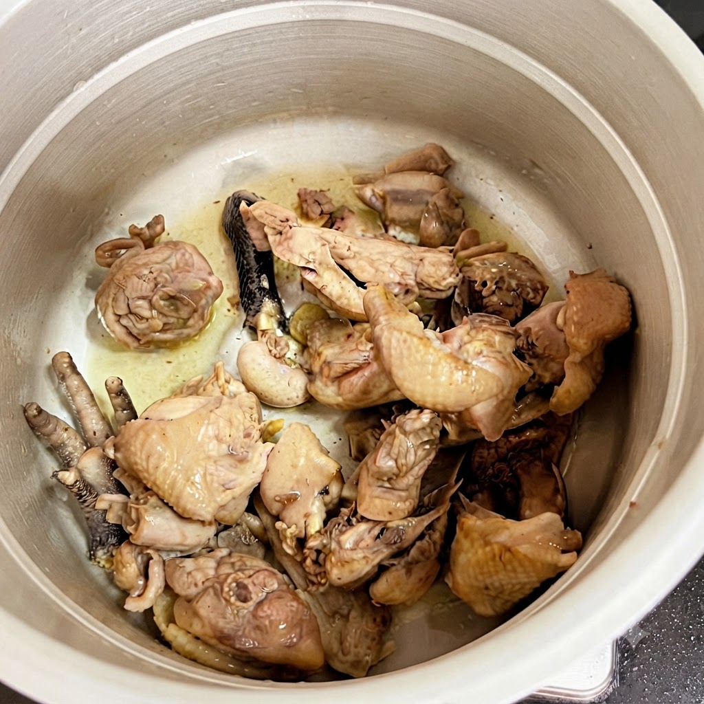 Cooked chicken pieces sitting inside the pressure cooker pot.