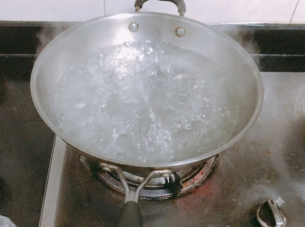 Long pasta noodles cooking in a pan of boiling salted water.