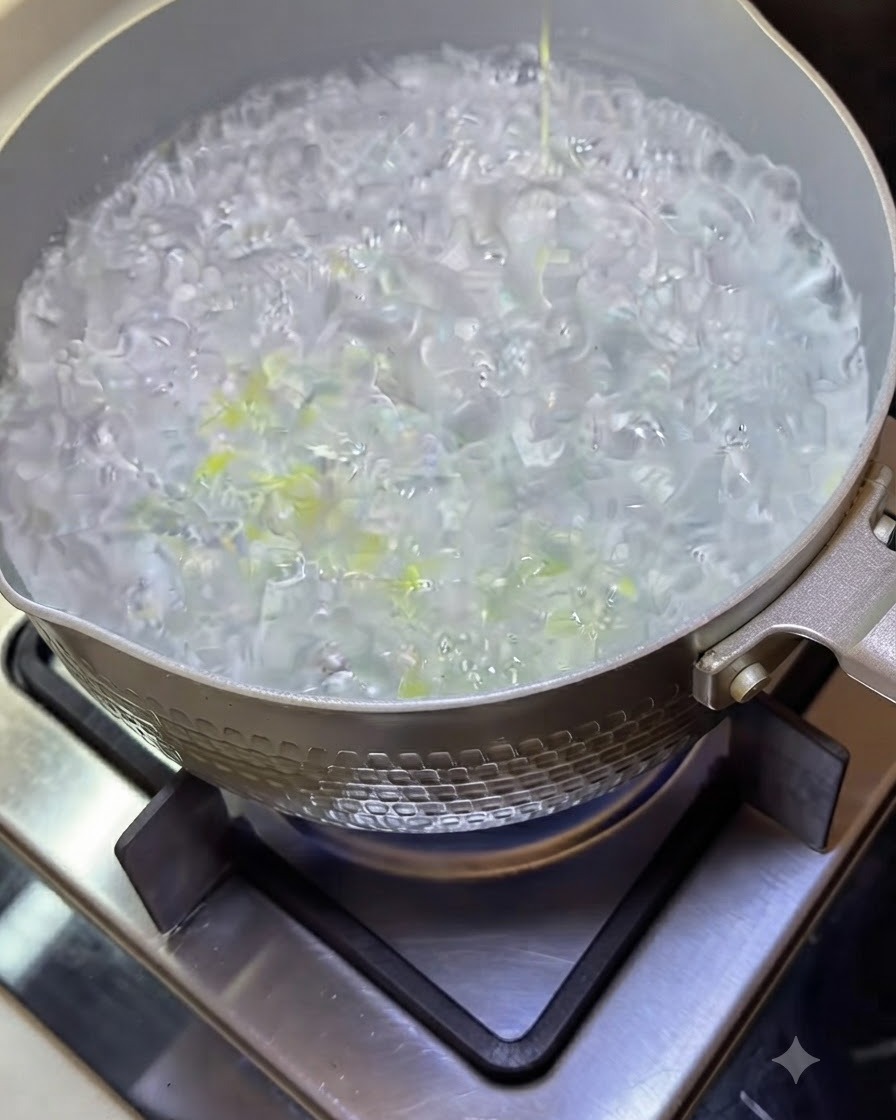 Spaghetti noodles cooking in a pot of boiling water with bubbling liquid.