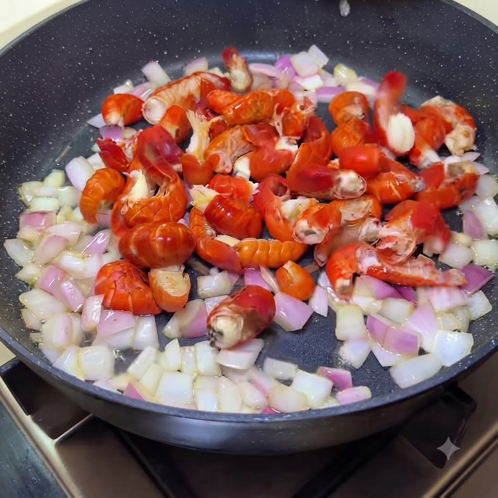 Crawfish tails mixed with sautéed onions in a pan.