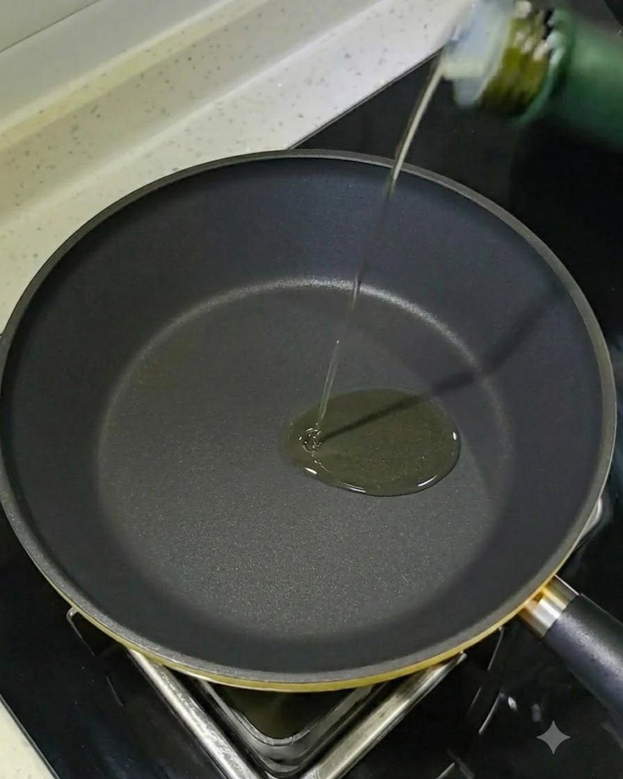 Raw shrimp being pan-seared in a hot oiled skillet until golden.