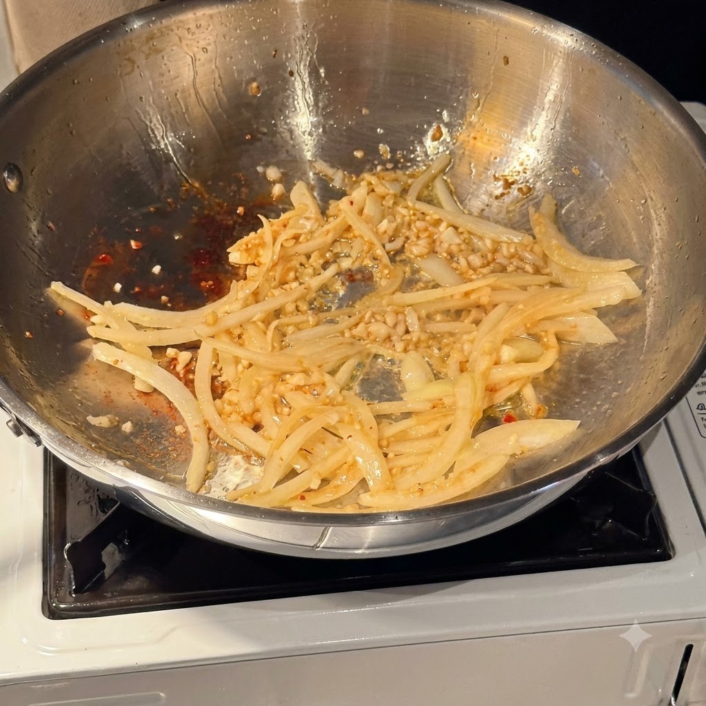 White wine being poured into a pan containing sautéed onions and garlic.