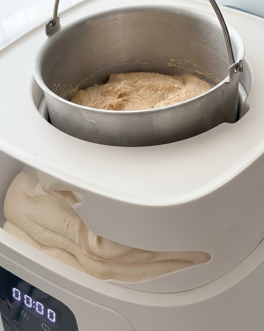 The paddle mechanism being attached and secured inside the ice cream maker machine.