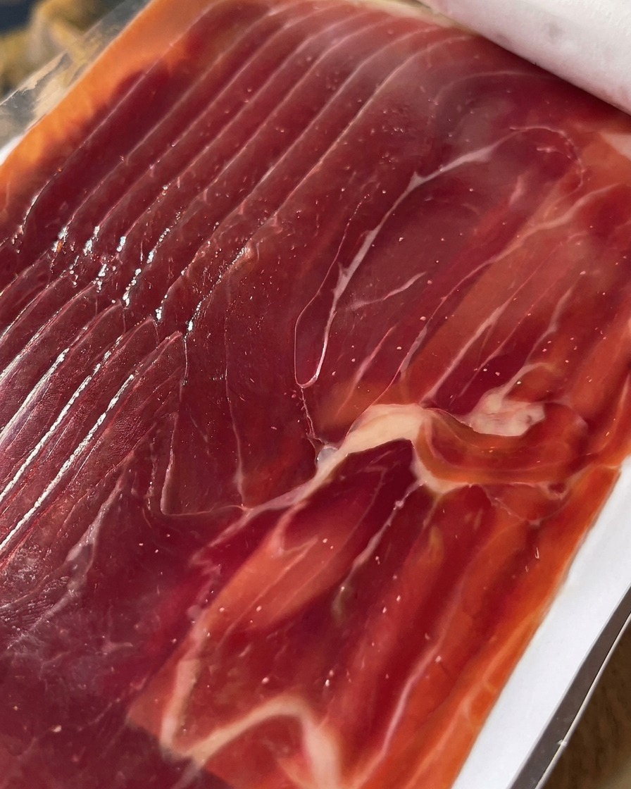 Close-up of neatly sliced prosciutto ready to be layered onto the figs.