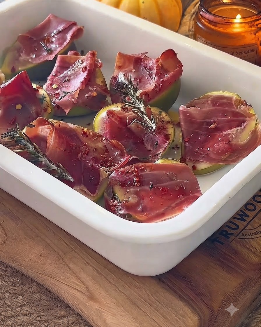 Baked figs in a white dish being drizzled with balsamic glaze.