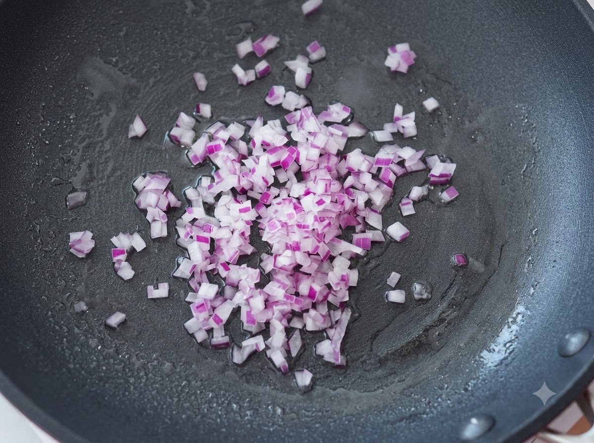 Finely diced purple onions being stir-fried in a hot pan with oil.