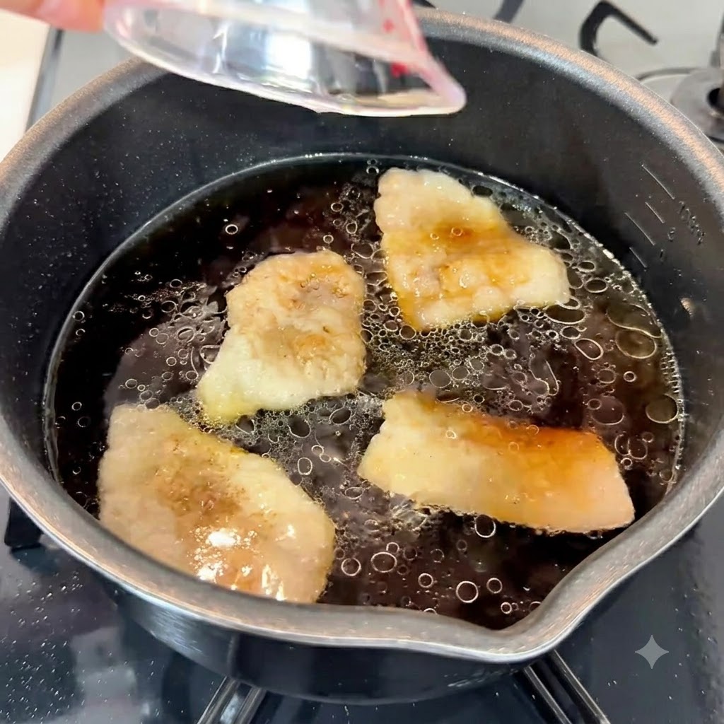 Garlic paste, sesame oil, and white sugar being poured into the dark flavorful soup base in a pot.