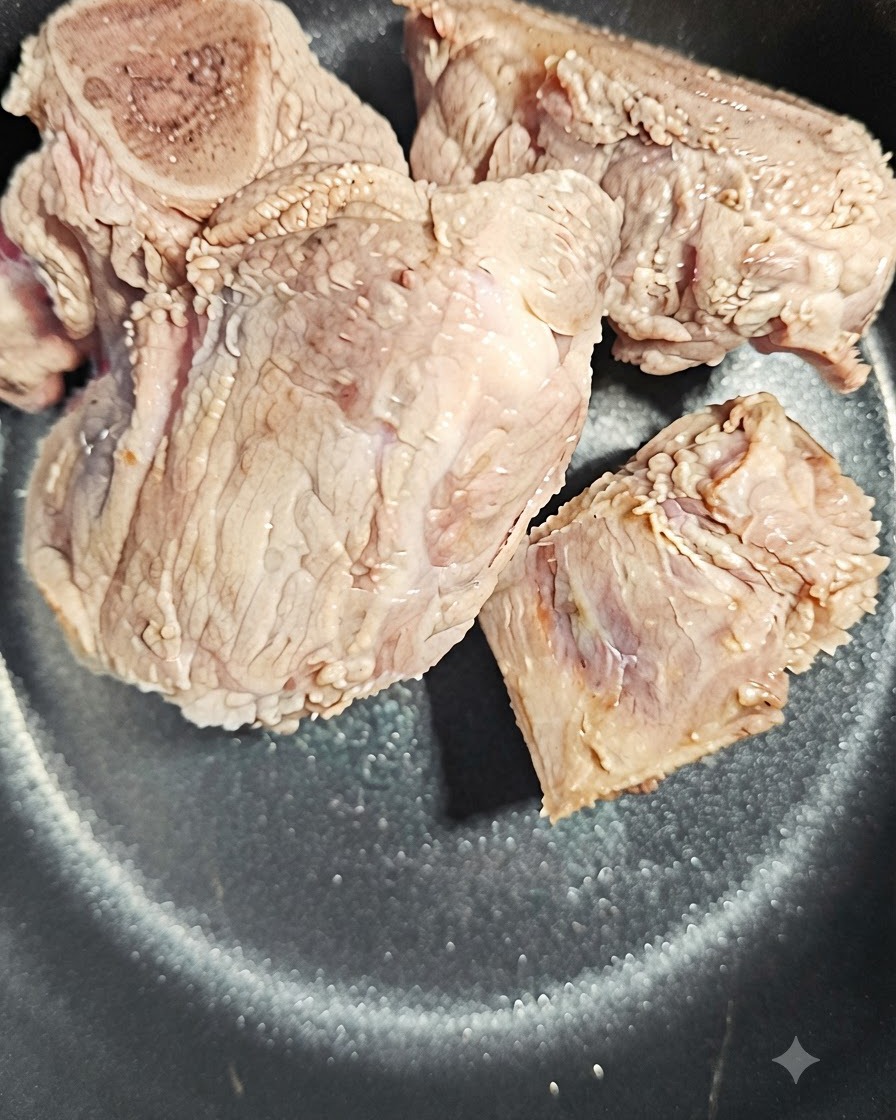 A slice of angelica root placed next to the pork bones in the pot.