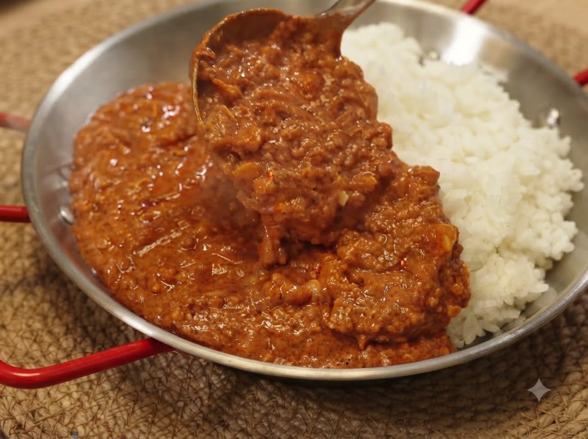 A ladle scooping rich curry minced pork sauce over a bed of white rice in a serving pan.