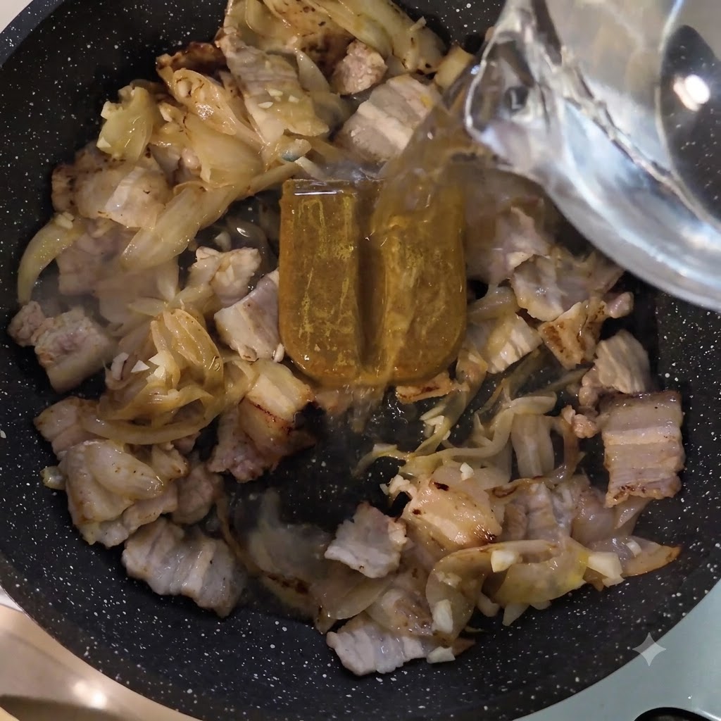 Water being poured from a container into the frying pan over the curry paste and meat.