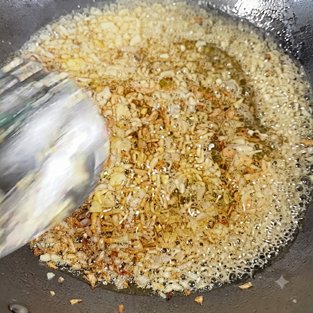Minced garlic and diced onion frying in hot oil in a wok.