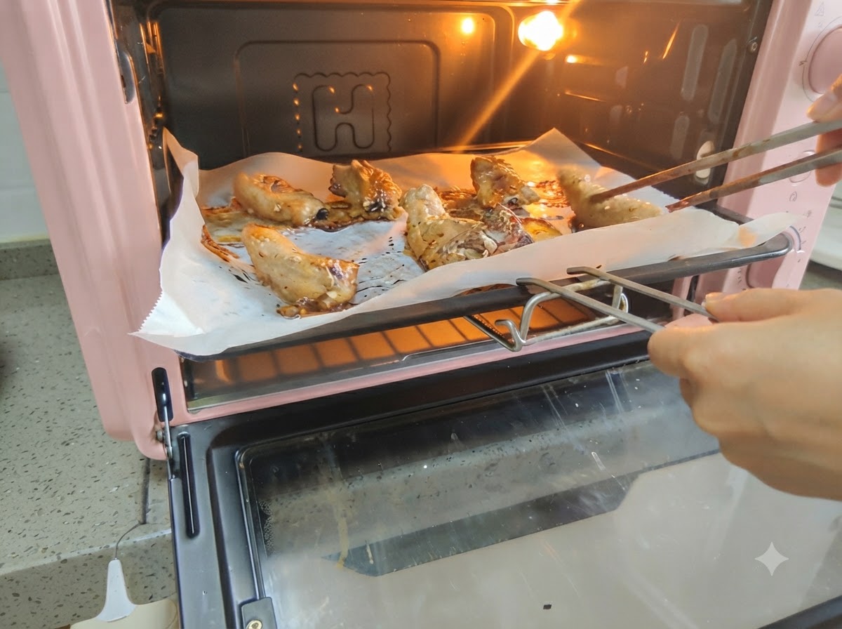 Pork ribs being turned over inside the hot oven using a pair of chopsticks.