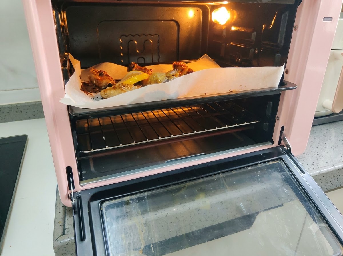 Fresh lemon slices arranged on the baking sheet next to the roasting pork ribs.