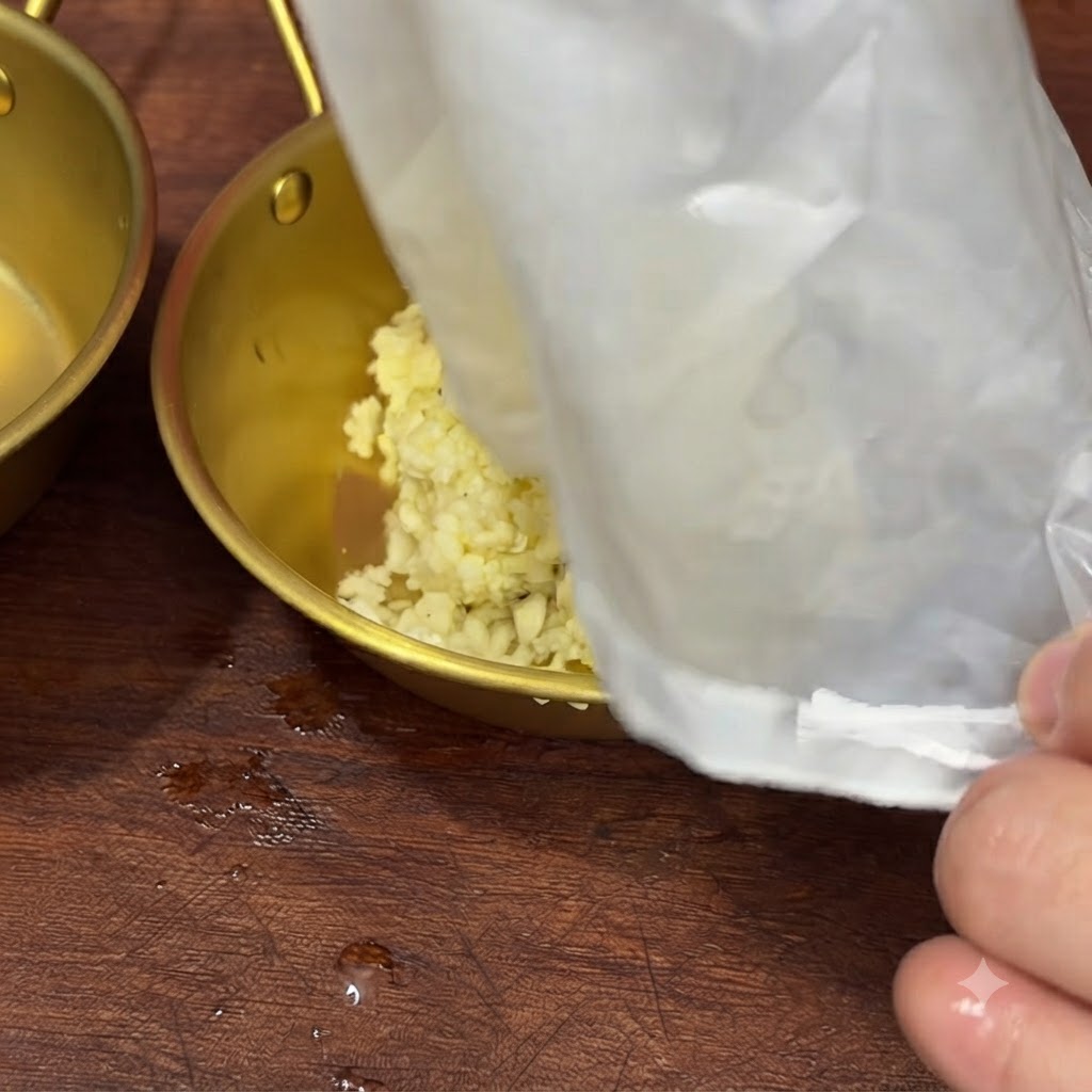 Transferring the leftover minced garlic from a filter bag into a bowl.