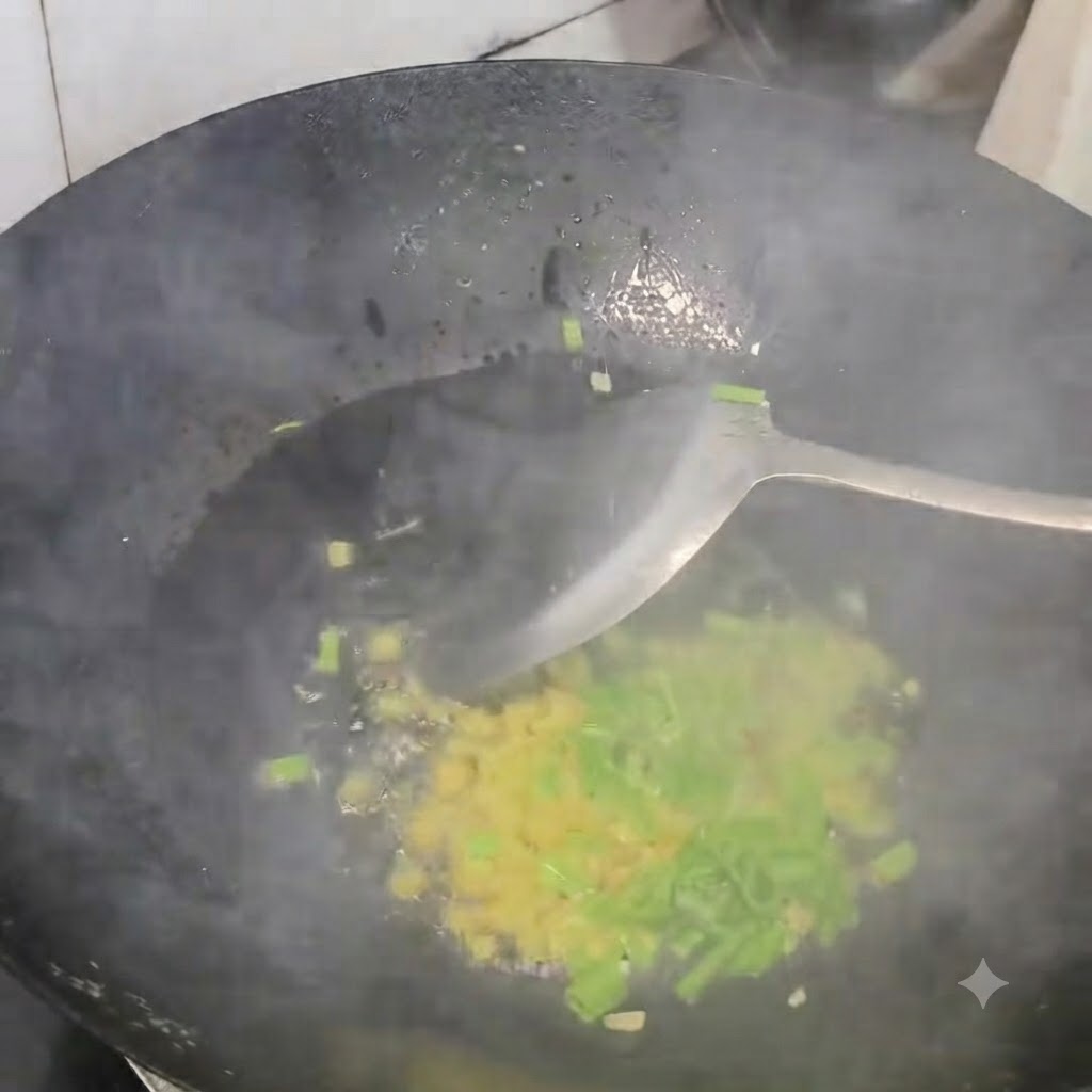 Minced scallions, ginger, and garlic being stir-fried in a hot black wok with a spatula.