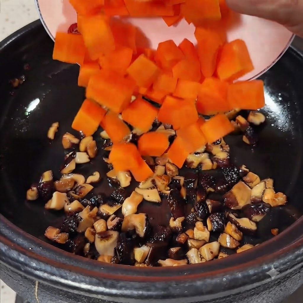 Bright orange diced carrots being poured from a plate into the pot containing sautéed mushrooms.