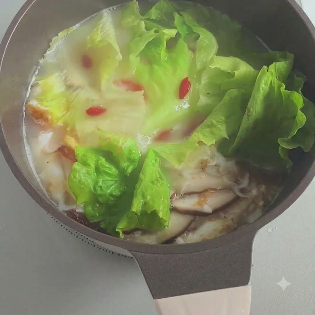 Chopped green onions being sprinkled into the simmering pot of soup.