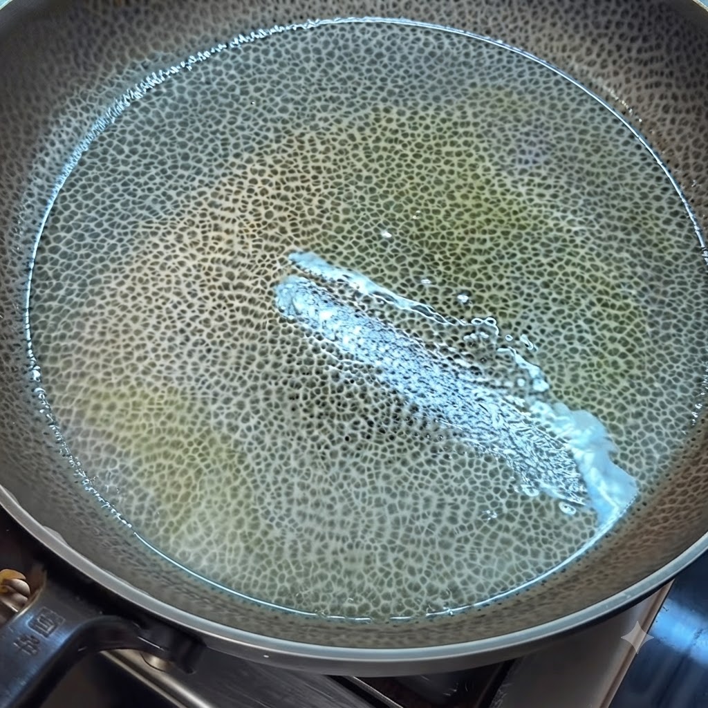 Beaten egg liquid cooking and being scrambled into pieces in a greased pan with a spatula.