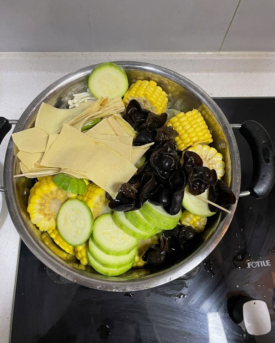 Assembled vegetables with kimchi placed on top inside the cooking pot.