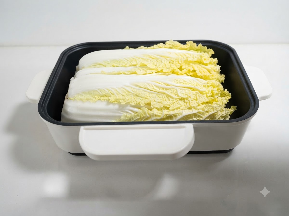 Cabbage leaves neatly placed inside a white square shallow pot.