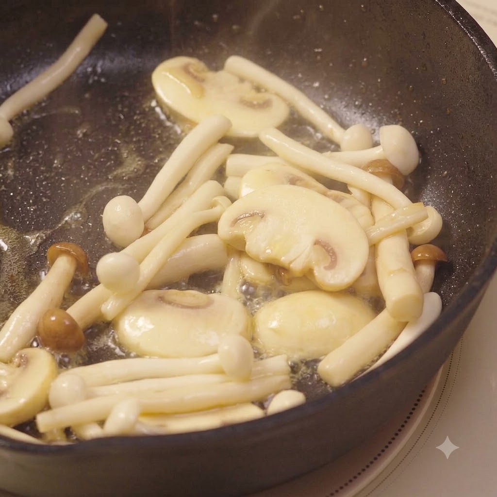 Minced garlic mixed into the frying mushrooms being stirred with a spatula.